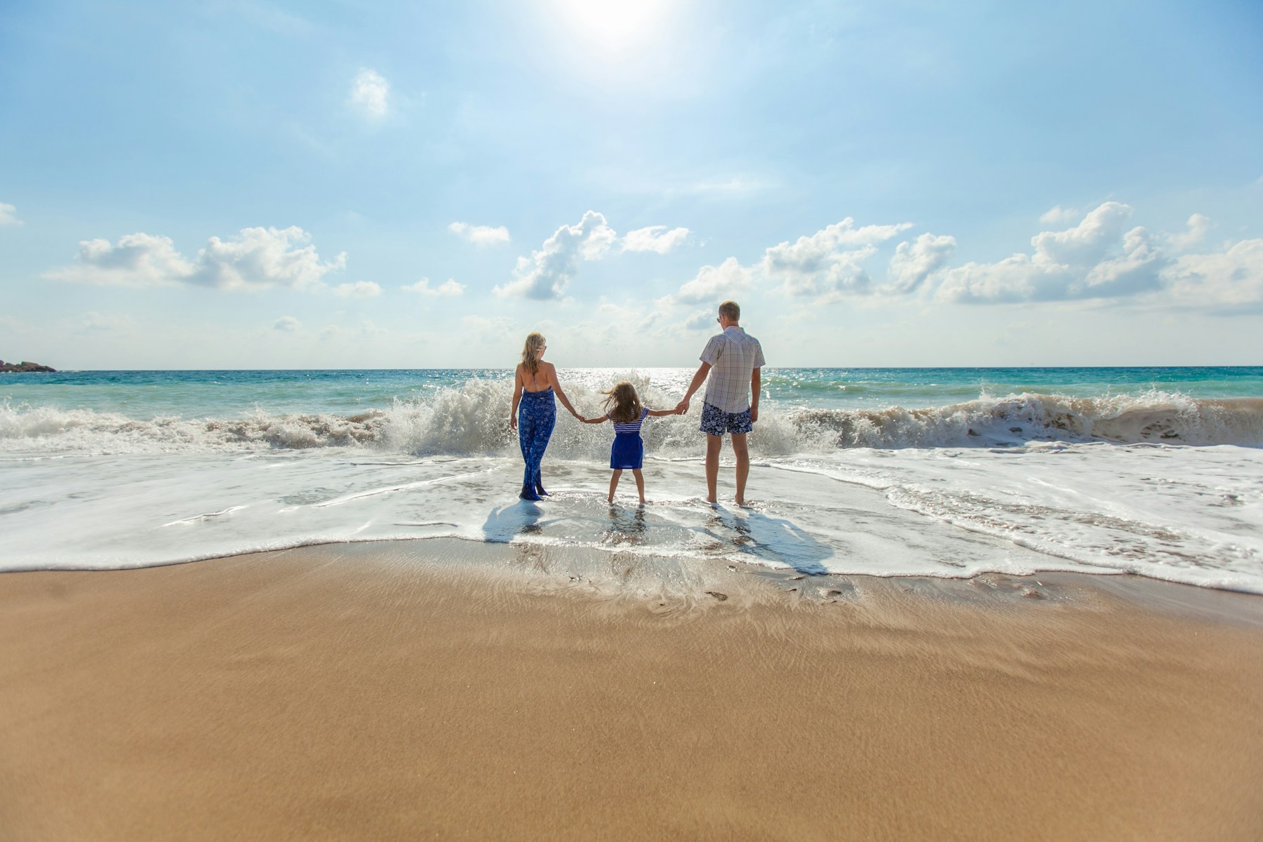 一家人在海邊牽手旅行